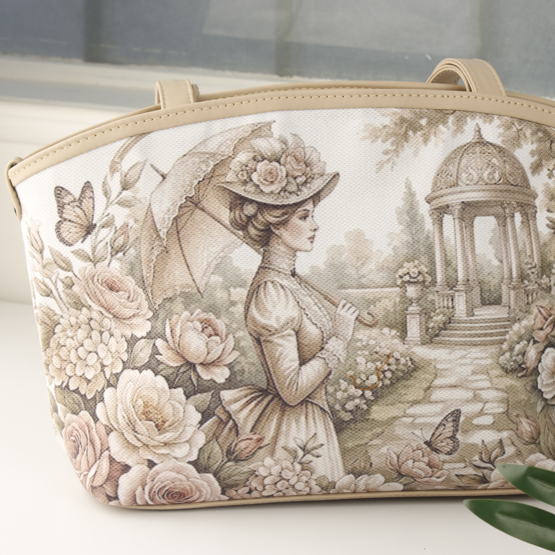 Close-up of beige tote bag showing Victorian garden girl with parasol amid roses and butterflies