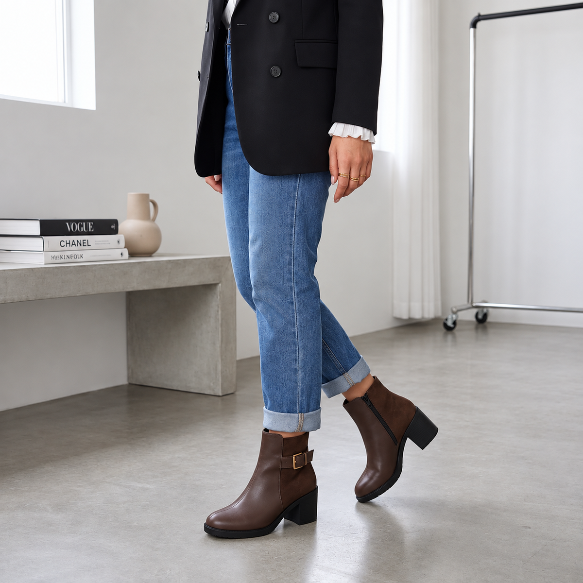 Full length view of model wearing chocolate brown block heel ankle boots with rolled denim and black blazer.