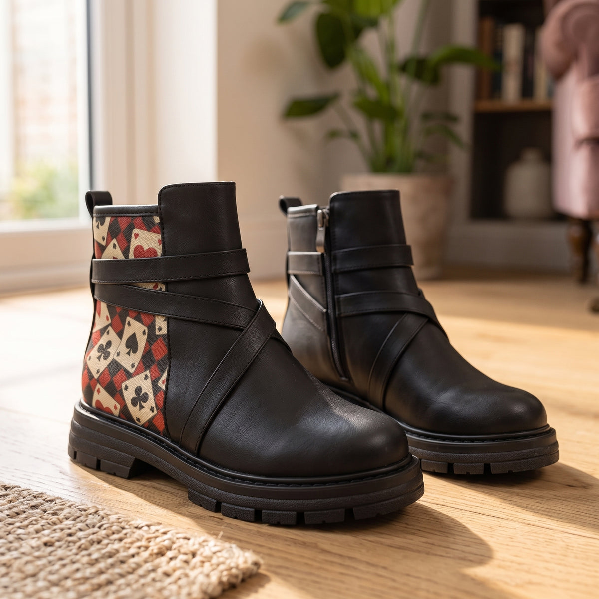 Pair of ECADRA Street Mode black ankle boots with Queen of Hearts playing cards print and crossed straps on wooden floor