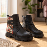 Pair of ECADRA Street Mode black ankle boots with Queen of Hearts playing cards print and crossed straps on wooden floor
