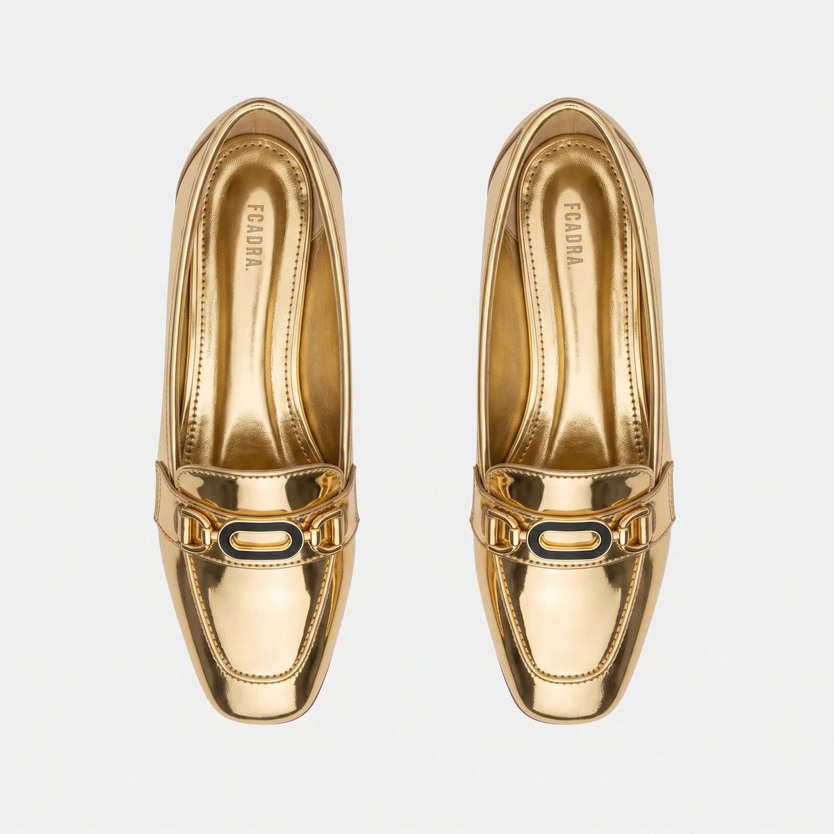 Top-down overhead view of pair of shiny gold flats displaying the printed ECADRA inner sole.