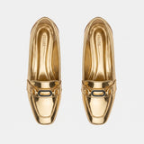 Top-down overhead view of pair of shiny gold flats displaying the printed ECADRA inner sole.