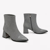 Gray suede signature cap-toe ankle boots with mid block heel and side zip on white background.