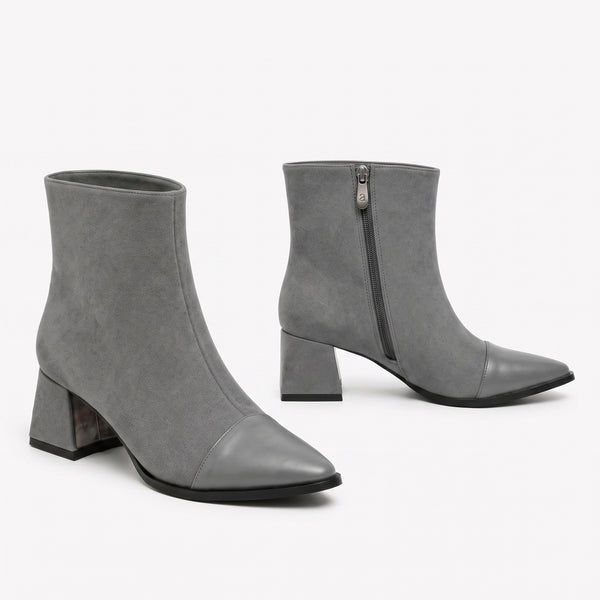 Gray suede signature cap-toe ankle boots with mid block heel and side zip on white background.