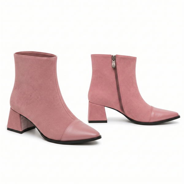 Dusty pink suede block heel booties with smooth leather cap toe on white background.