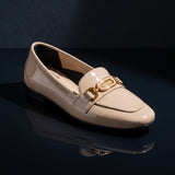 Single glossy beige patent ECADRA loafer displayed on a dark reflective surface, showcasing its gold-tone hardware buckle.