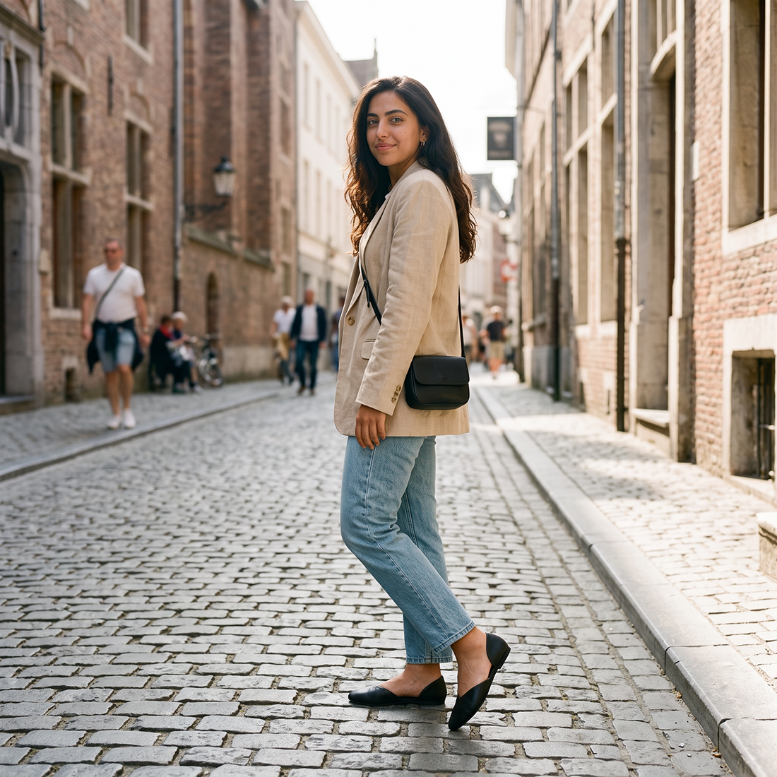 Woman glancing back in black open-side d'Orsay Wink Flats with jeans on a cobblestone street | ECADRA