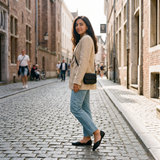 Woman glancing back in black open-side d'Orsay Wink Flats with jeans on a cobblestone street | ECADRA