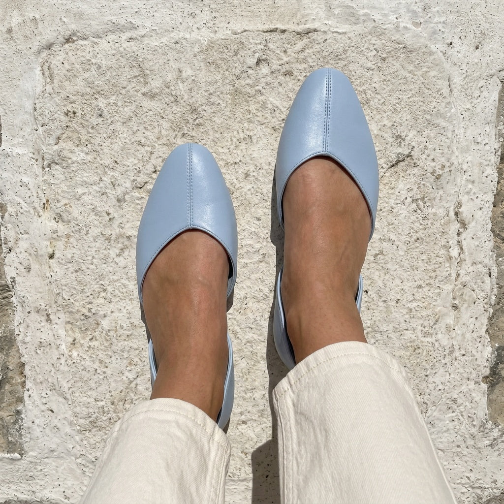 Overhead view of blue open-side Wink Flats worn with jeans on white Mediterranean pavement | ECADRA
