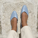 Overhead view of blue open-side Wink Flats worn with jeans on white Mediterranean pavement | ECADRA