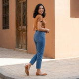 Woman glancing back in tan open-side d'Orsay Wink Flats with cropped jeans on a Cairo street | ECADRA