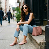 Woman in navy top and jeans sitting on city steps wearing rose open-side Wink Flats | ECADRA