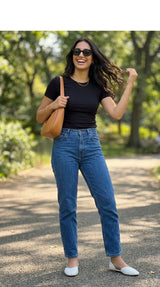 Woman in white Wink Flats, black top and blue jeans enjoying a sunny park | ECADRA