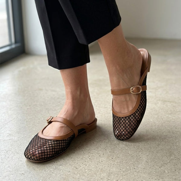 Woman wearing ECADRA Mary Jane Mules featuring a breathable black mesh upper and an adjustable tan faux leather buckle strap.