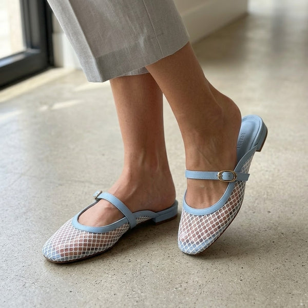 Woman wearing light blue ECADRA Mary Jane Mules featuring a breathable white mesh upper and an adjustable faux leather buckle strap.
