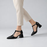 Black gloss T-strap heels with wide strap, silver buckle and 5 cm flared heel, worn on model, walking — ECADRA
