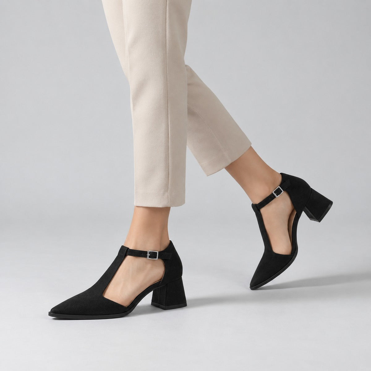 Black suede T-strap heels with wide strap, silver buckle and 5 cm flared heel, worn on model, walking — ECADRA