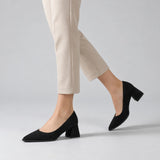 Black suede pointed pump with low 5 cm flared block heel, worn on model, walking — ECADRA
