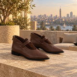 Brown pointed-toe ankle boots with three coiled straps — pair on a Zamalek rooftop — ECADRA