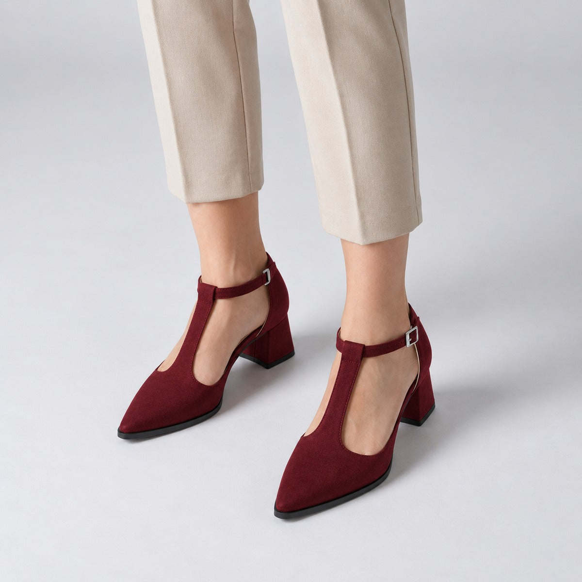 Burgundy suede T-strap heels with wide strap, silver buckle and 5 cm flared heel, worn on model, front — ECADRA