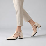 Cream matte T-strap heels with wide strap, silver buckle and 5 cm flared heel, worn on model, walking — ECADRA
