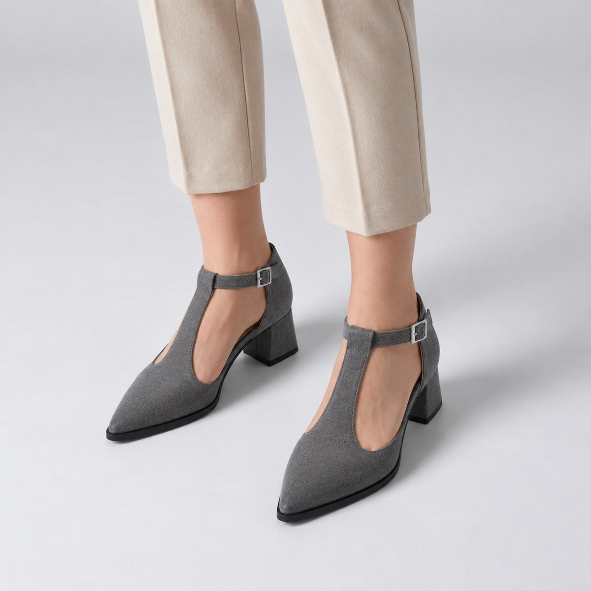 Gray suede T-strap heels with wide strap, silver buckle and 5 cm flared heel, worn on model, front — ECADRA