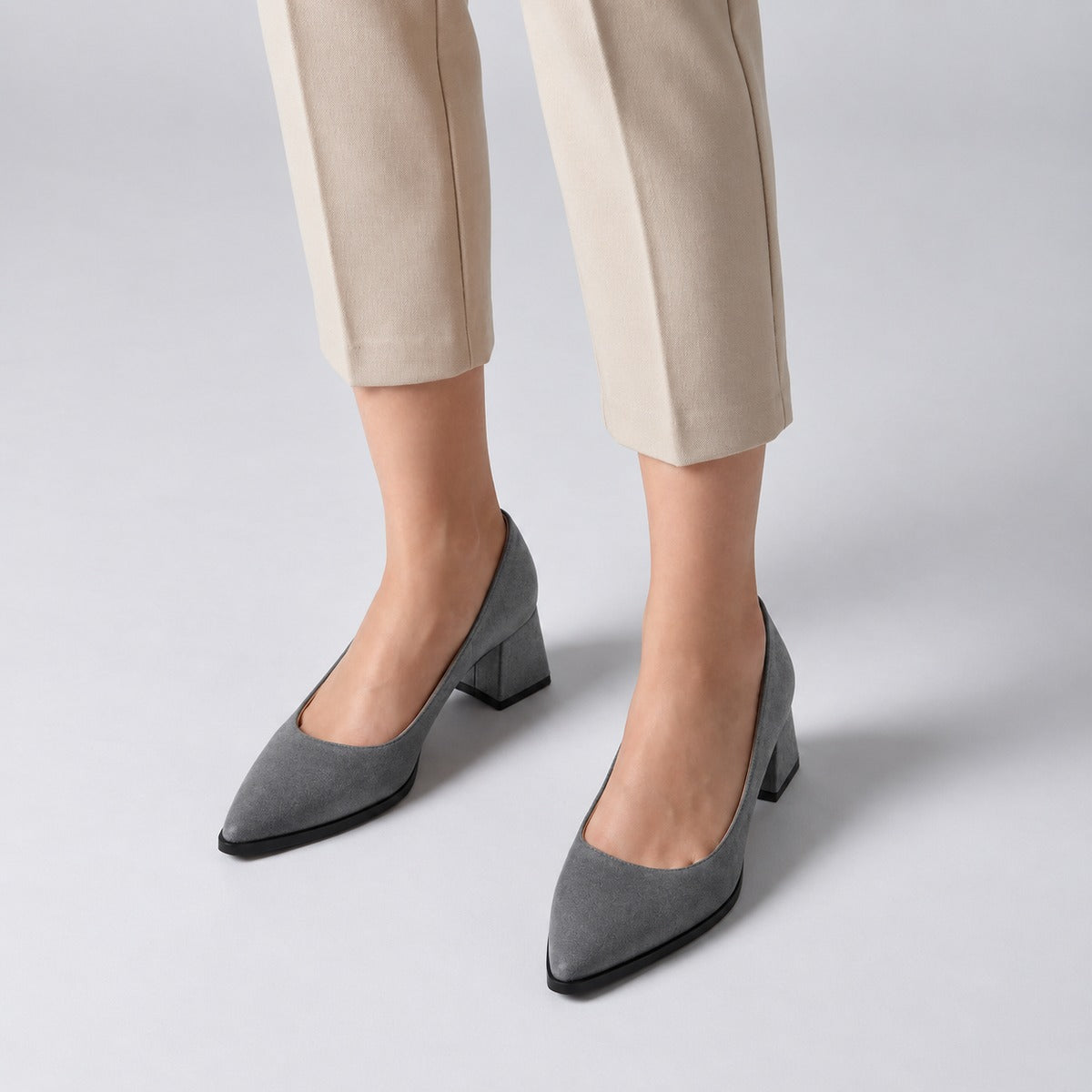 Gray suede pointed pump with low 5 cm flared block heel, worn on model, front — ECADRA