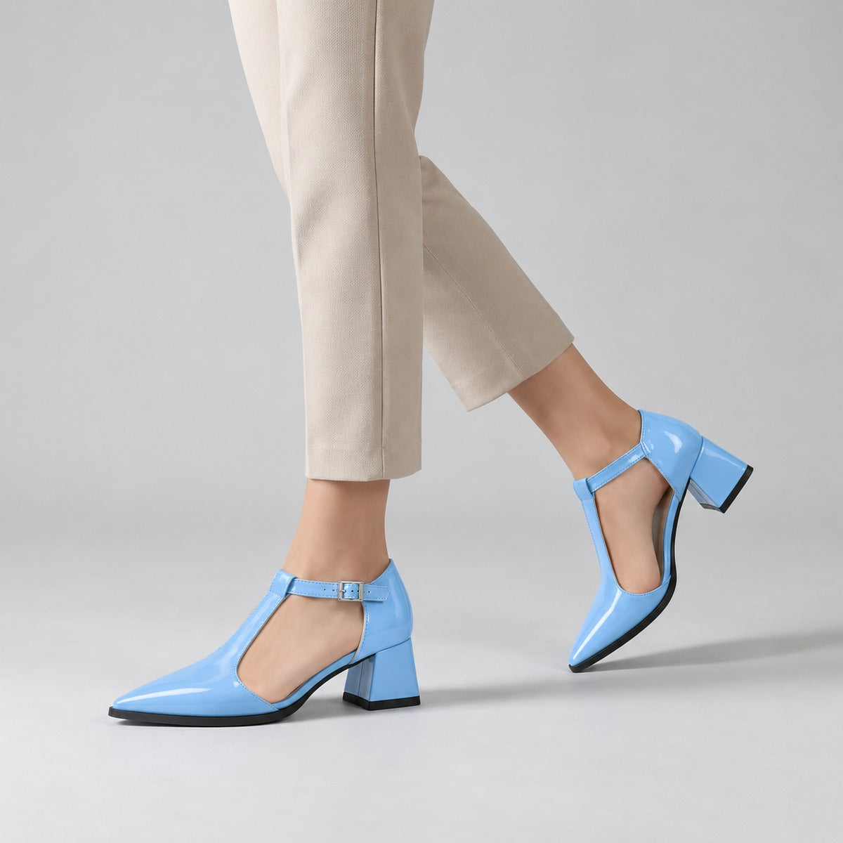 Light Blue gloss T-strap heels with wide strap, silver buckle and 5 cm flared heel, worn on model, walking — ECADRA