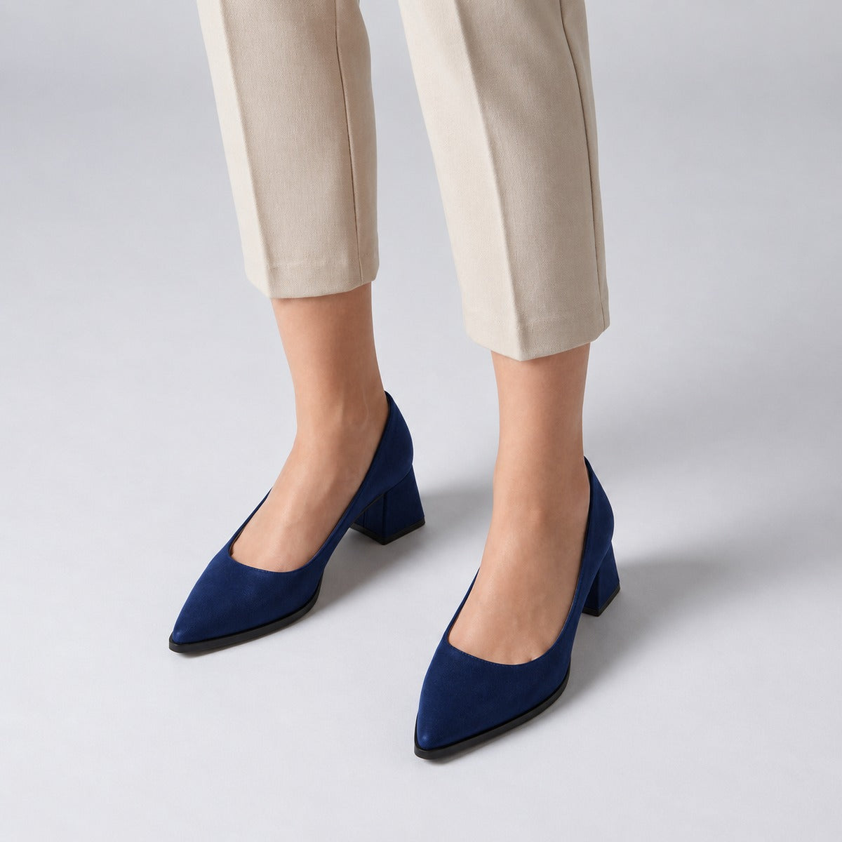 Navy suede pointed pump with low 5 cm flared block heel, worn on model, front — ECADRA
