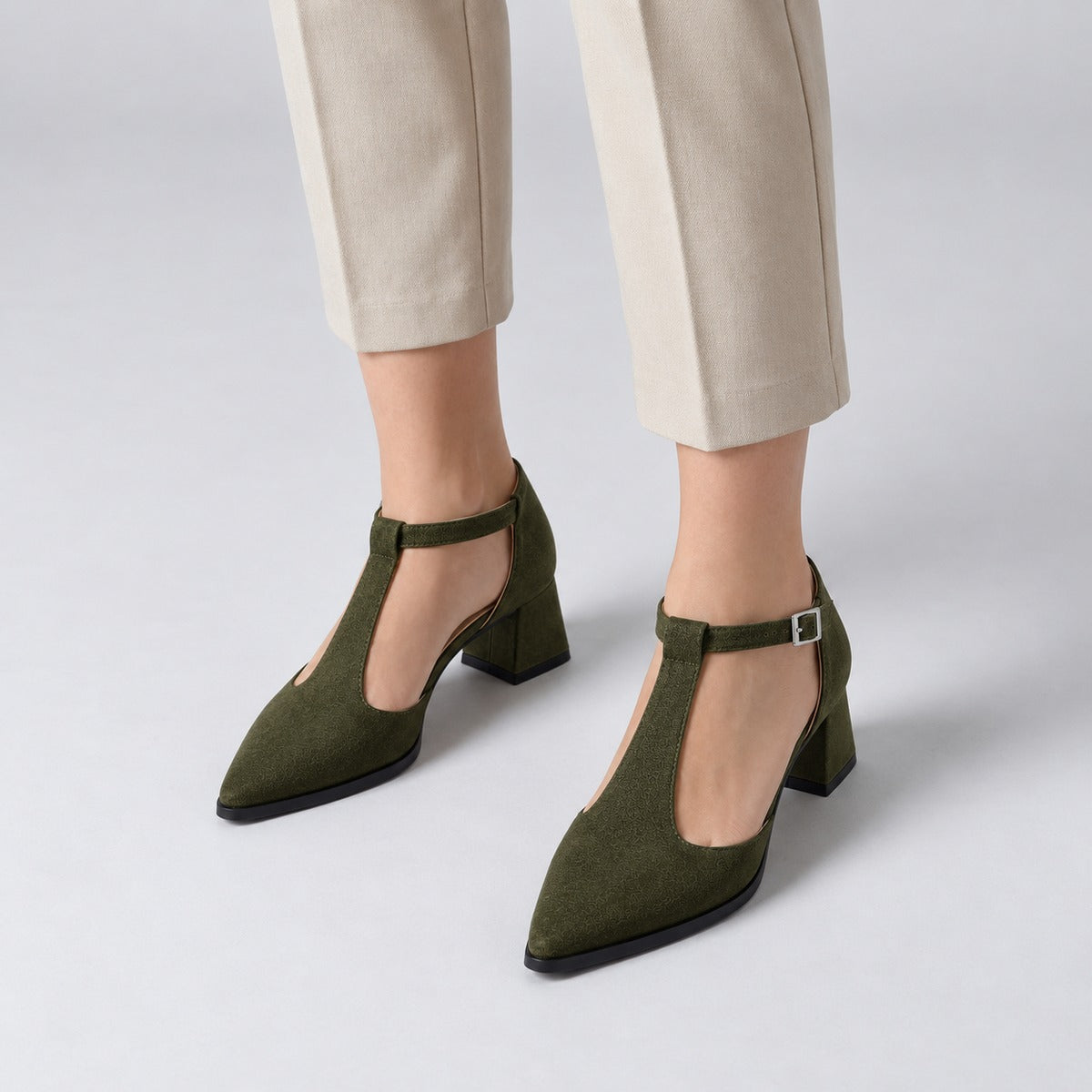 Olive suede T-strap heels with wide strap, silver buckle and 5 cm flared heel, worn on model, front — ECADRA