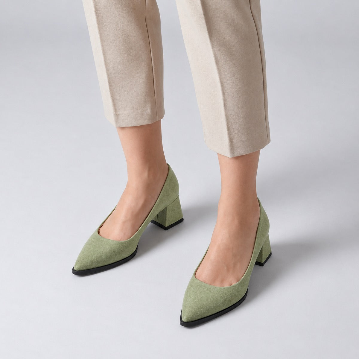 Pistachio suede pointed pump with low 5 cm flared block heel, worn on model, front — ECADRA