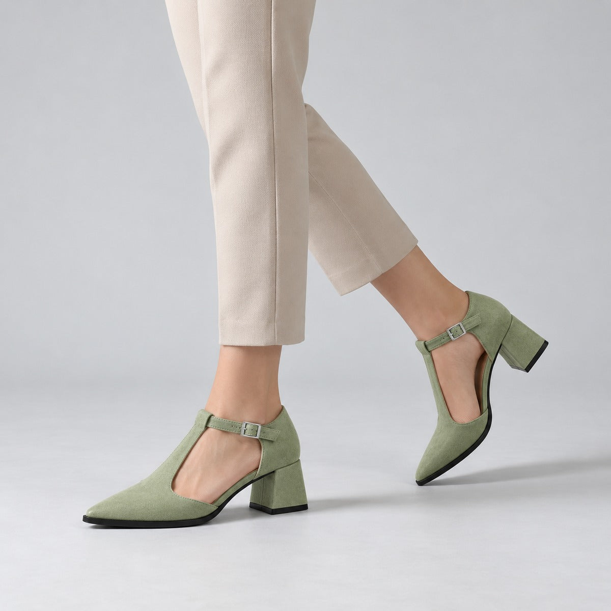Pistachio suede T-strap heels with wide strap, silver buckle and 5 cm flared heel, worn on model, walking — ECADRA