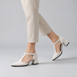 White suede T-strap heels with wide strap, silver buckle and 5 cm flared heel, worn on model, walking — ECADRA